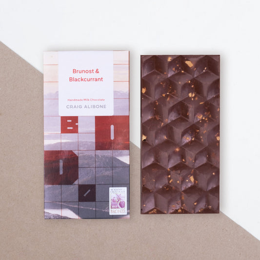 Photo of a chocolate bar packaging sized by side with the unpacked chocolate bar.  You can see the beautifully designed packaging and textured pattern on the chocolate bar.