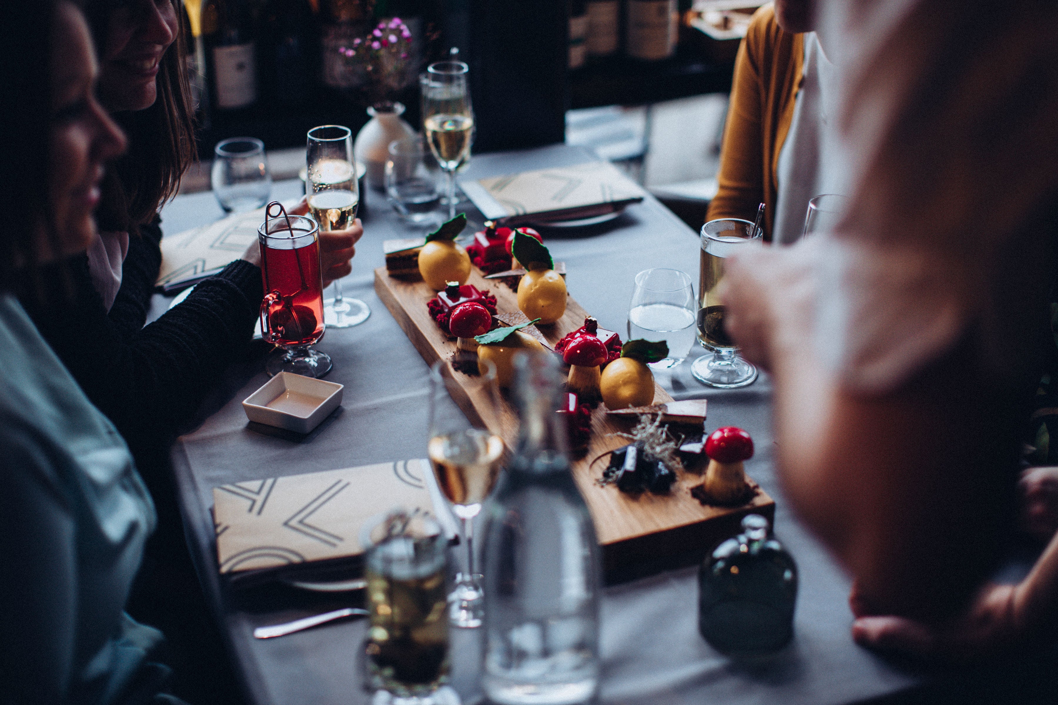 CraigAliboneBrunch chocolate table photo Rich colours and beautiful chocolates on a wooden board surrounded by people sitting at the table.