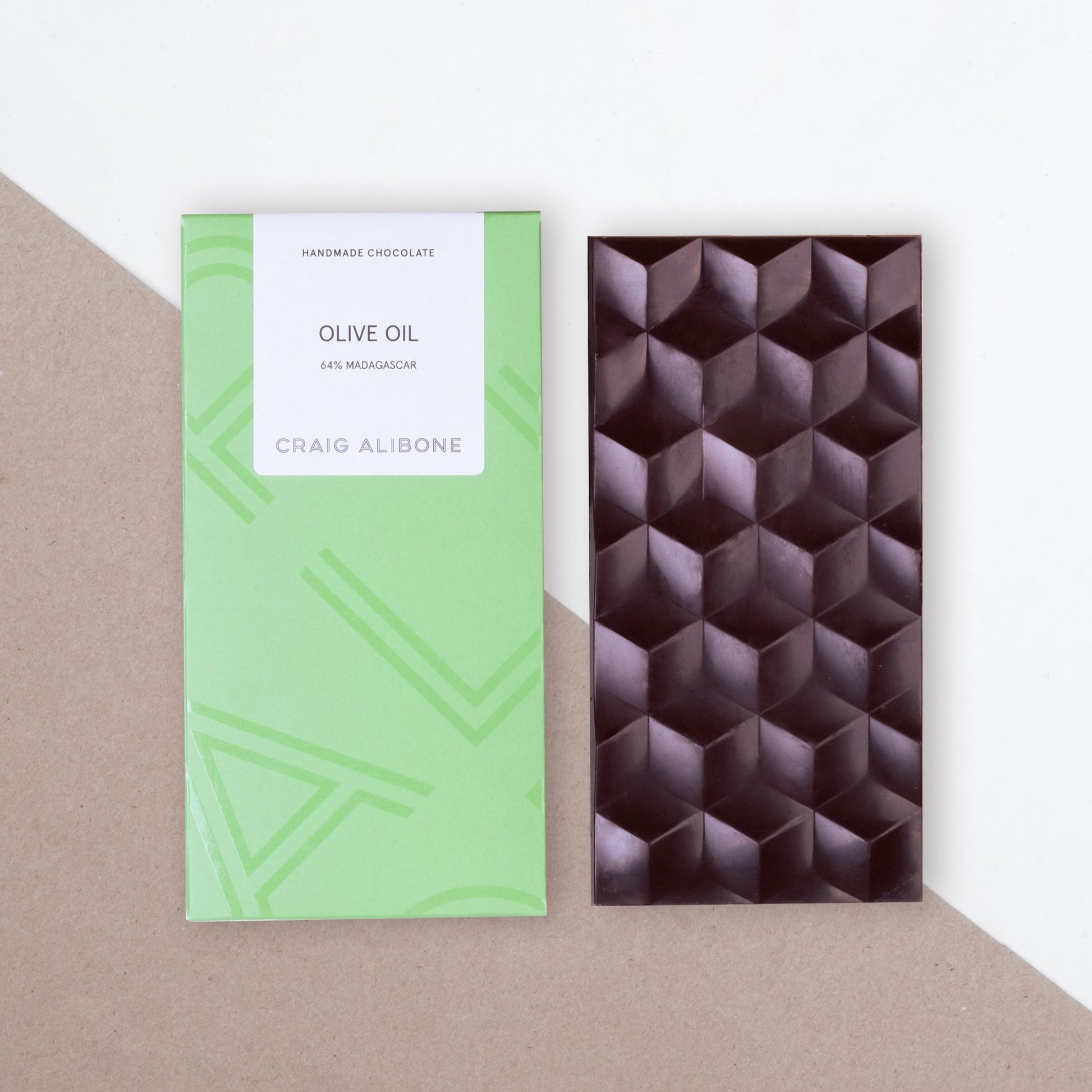 Photo of a chocolate bar packaging sized by side with the unpacked chocolate bar.  You can see the beautifully designed packaging and textured pattern on the chocolate bar. 