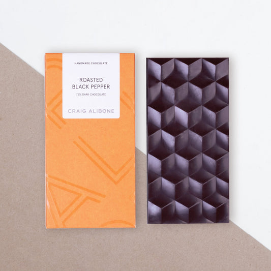 Photo of a chocolate bar packaging sized by side with the unpacked chocolate bar.  You can see the beautifully designed packaging and textured pattern on the chocolate bar. 