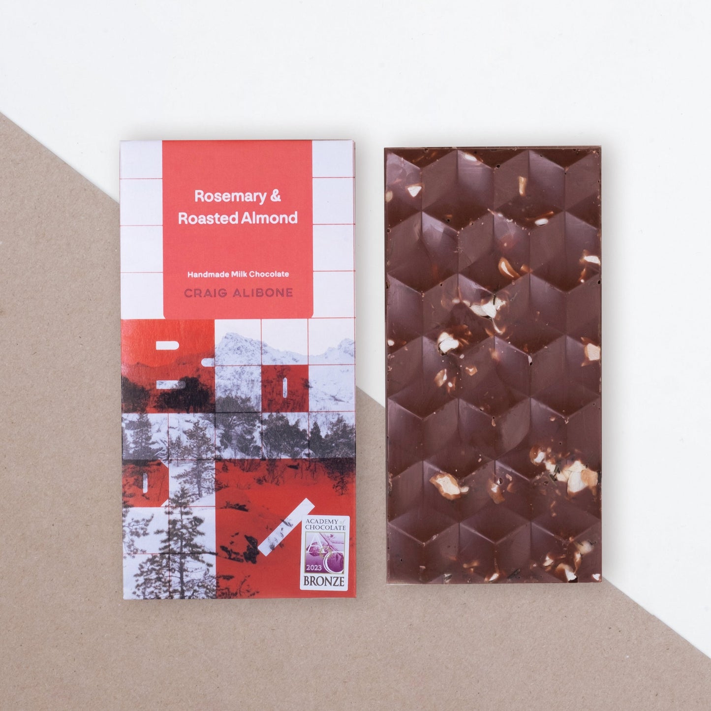 Photo of a chocolate bar packaging sized by side with the unpacked chocolate bar.  You can see the beautifully designed packaging and textured pattern on the chocolate bar. 