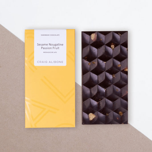  Photo of a chocolate bar packaging sized by side with the unpacked chocolate bar.  You can see the beautifully designed packaging and textured pattern on the chocolate bar. 