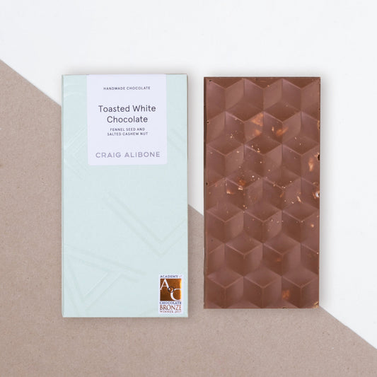 Photo of a chocolate bar packaging sized by side with the unpacked chocolate bar.  You can see the beautifully designed packaging and textured pattern on the chocolate bar. 